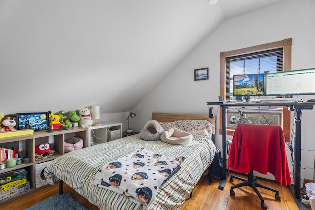 bedroom featuring wood finished floors and vaulted ceiling