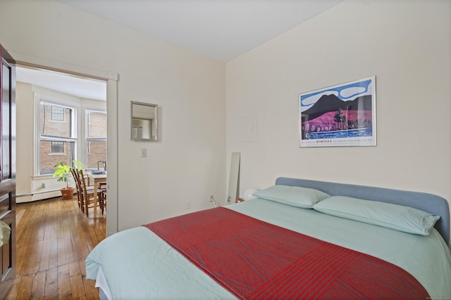 bedroom featuring hardwood / wood-style floors and a baseboard radiator