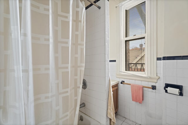 bathroom with tile patterned floors, vanity, tile walls, and shower / bath combination