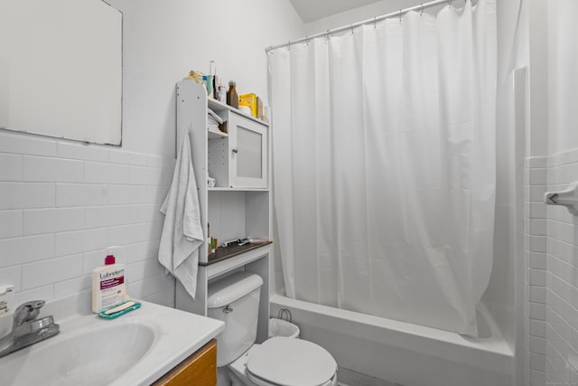 full bath featuring a wainscoted wall, toilet, vanity, shower / tub combo, and tile walls