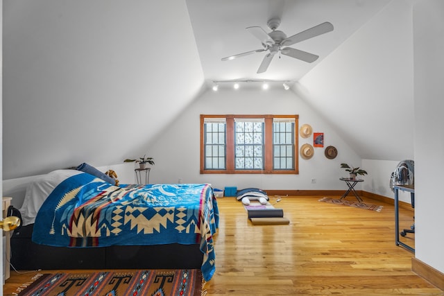 bedroom featuring vaulted ceiling, wood finished floors, baseboards, and ceiling fan