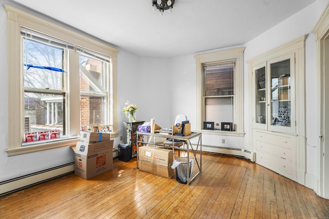 office space with a baseboard heating unit and hardwood / wood-style floors