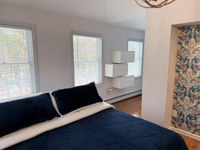 bedroom featuring baseboards, baseboard heating, and wood finished floors