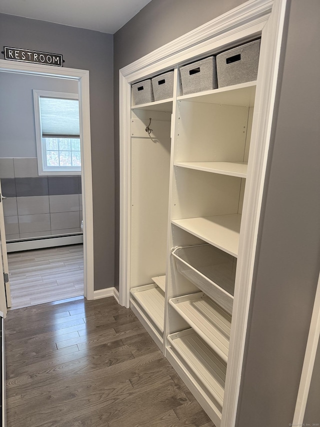 mudroom featuring dark wood finished floors, baseboards, and a baseboard radiator