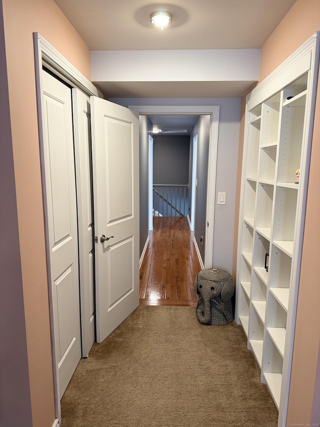 corridor featuring an upstairs landing and carpet floors