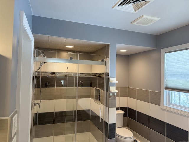 full bathroom with visible vents, toilet, and a stall shower