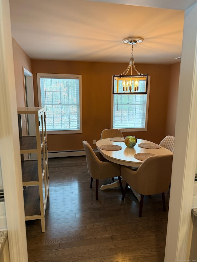 dining area with an inviting chandelier, dark wood-style flooring, and baseboard heating