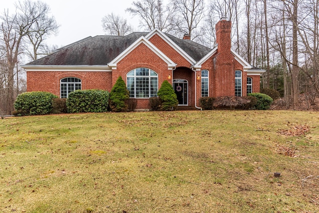 ranch-style home with a front yard, brick siding, roof with shingles, and a chimney