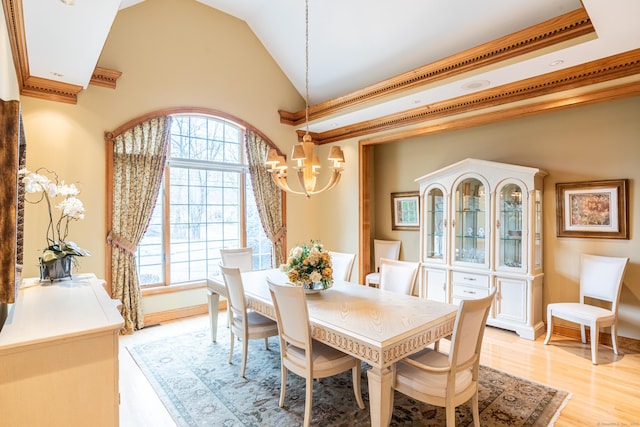 dining room featuring a chandelier, plenty of natural light, light wood finished floors, and crown molding