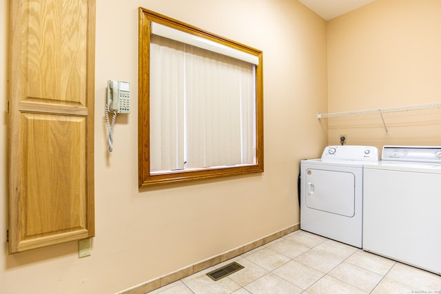 laundry room featuring visible vents, baseboards, laundry area, light tile patterned flooring, and separate washer and dryer