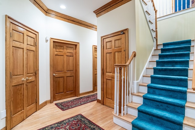 foyer entrance featuring stairway, wood finished floors, baseboards, recessed lighting, and ornamental molding