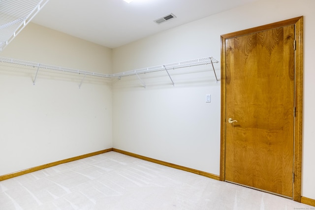 walk in closet with light colored carpet and visible vents