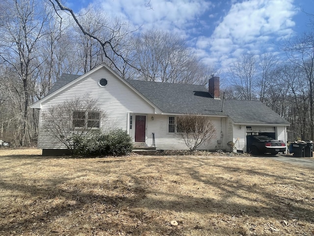 view of front of house with driveway, a garage, roof with shingles, and a chimney