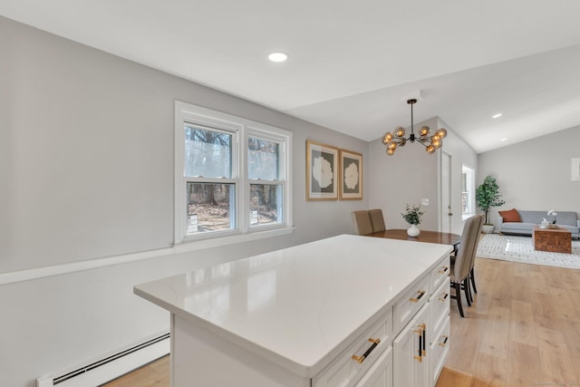 kitchen featuring lofted ceiling, white cabinets, light wood-style floors, open floor plan, and baseboard heating