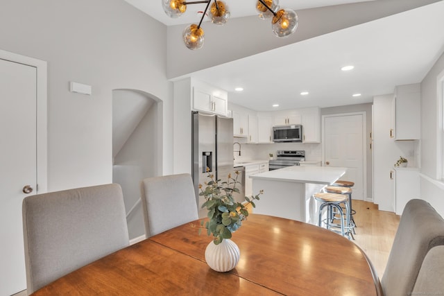 dining room with recessed lighting and light wood-style floors