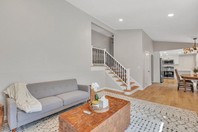 living area with recessed lighting, light wood-type flooring, stairs, and lofted ceiling