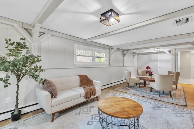 interior space featuring a baseboard radiator, beam ceiling, visible vents, and wood finished floors