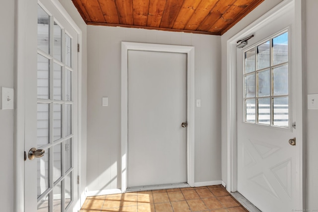 doorway to outside featuring light tile patterned floors and wood ceiling