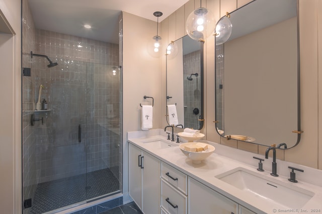 full bathroom with a shower stall, double vanity, and a sink