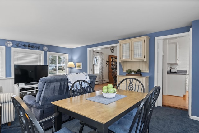 dining room with a baseboard radiator and dark carpet