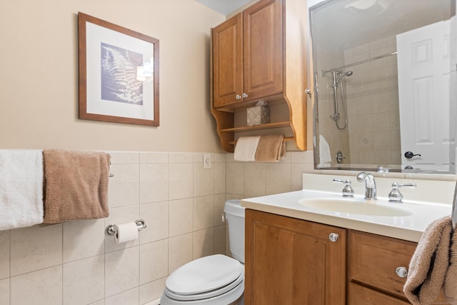 full bath featuring tiled shower / bath, toilet, tile walls, and vanity