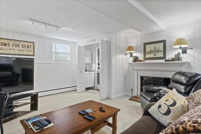 living area with carpet flooring, baseboard heating, a brick fireplace, and track lighting