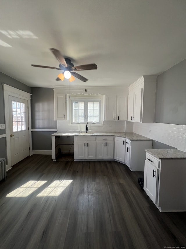 112 Concord St, Waterbury, CT 06710 - kitchen with decorative backsplash, white cabinets, a sink, ceiling fan, and dark wood-style floors