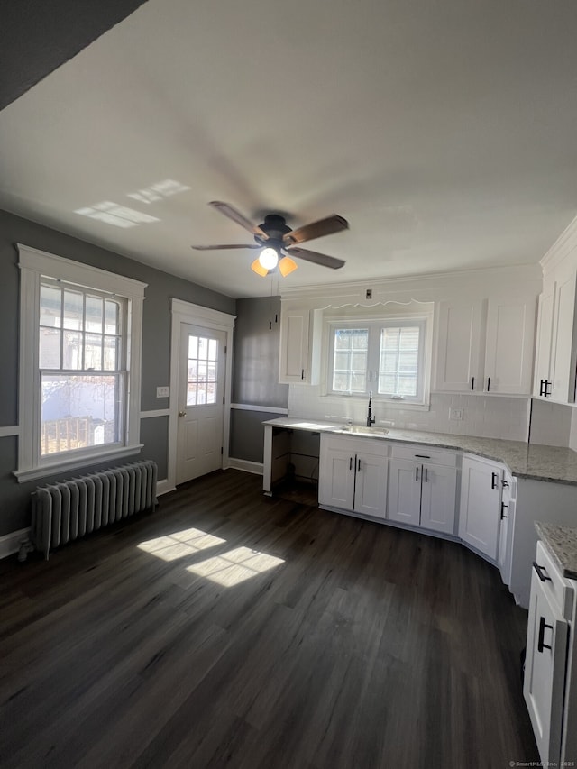 112 Concord St, Waterbury, CT 06710 - kitchen with a ceiling fan, radiator heating unit, backsplash, white cabinetry, and dark wood finished floors