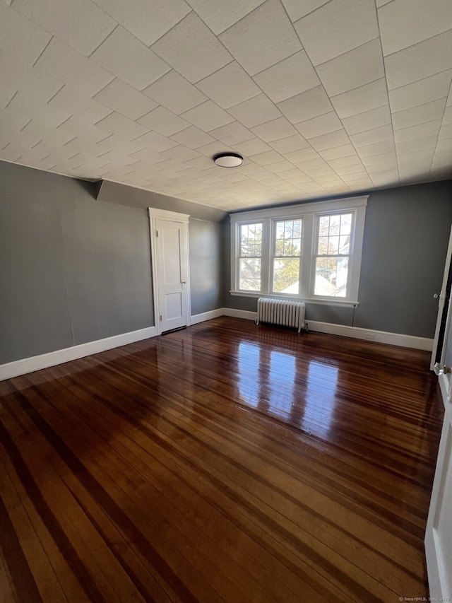 112 Concord St, Waterbury, CT 06710 - empty room featuring dark wood-style floors, radiator heating unit, and baseboards