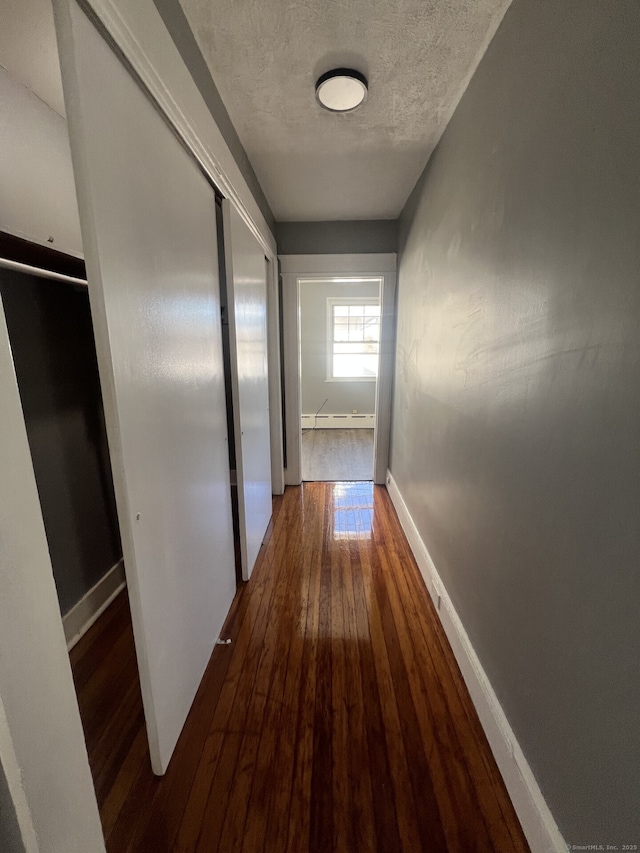 112 Concord St, Waterbury, CT 06710 - hallway featuring baseboards, baseboard heating, a textured ceiling, and wood-type flooring