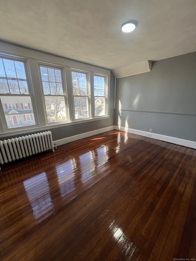 112 Concord St, Waterbury, CT 06710 - empty room with hardwood / wood-style floors, radiator heating unit, vaulted ceiling, and baseboards