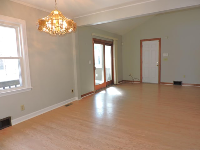 unfurnished room featuring an inviting chandelier, baseboards, visible vents, and light wood finished floors