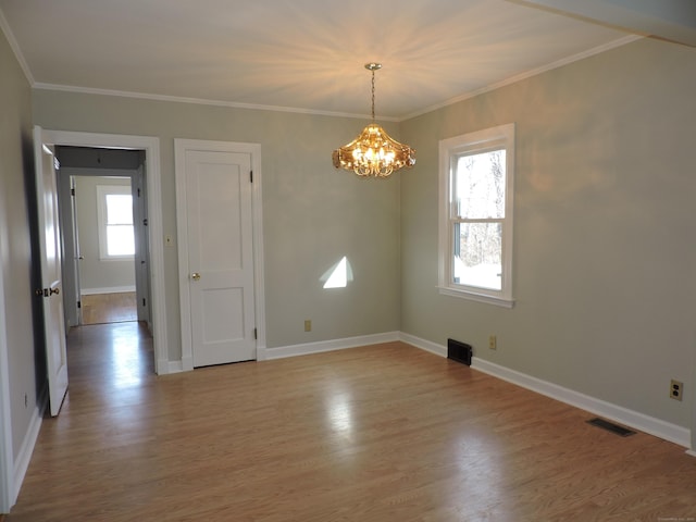 unfurnished room featuring light wood-style floors, an inviting chandelier, and crown molding