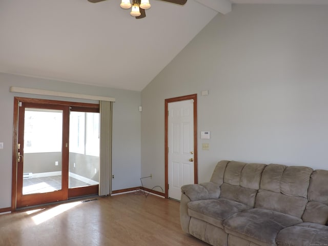 living room with visible vents, baseboards, beam ceiling, light wood-style floors, and high vaulted ceiling