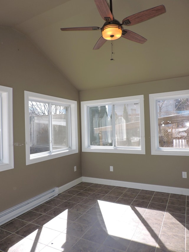 empty room featuring a baseboard heating unit, lofted ceiling, dark tile patterned flooring, and baseboards