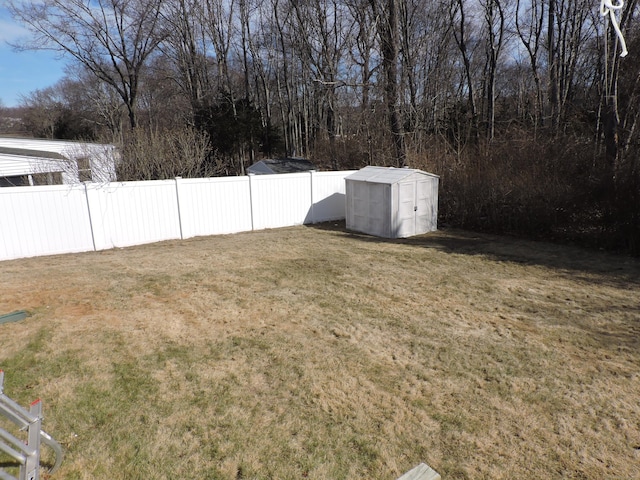 view of yard with an outbuilding, a storage unit, and fence