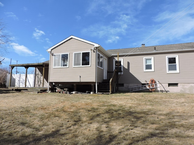 rear view of property featuring a lawn