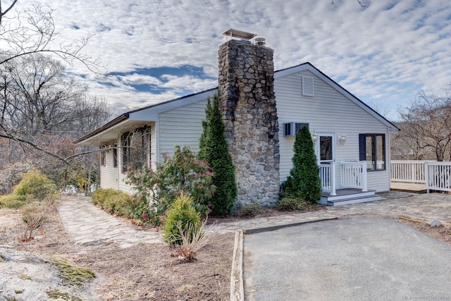 view of side of home featuring a deck and a chimney