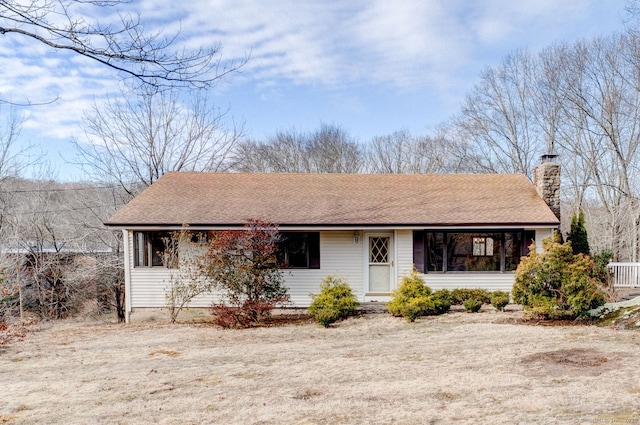 single story home featuring a chimney and a shingled roof