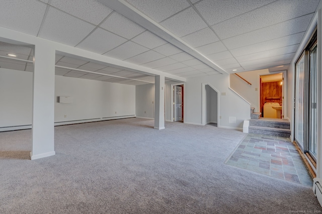 finished basement with a drop ceiling, stairs, carpet floors, baseboard heating, and washer / dryer