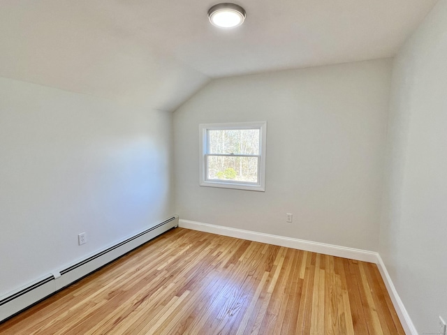 interior space featuring vaulted ceiling, light wood-style floors, baseboards, and baseboard heating