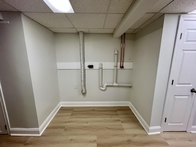 laundry area featuring laundry area, baseboards, and light wood finished floors