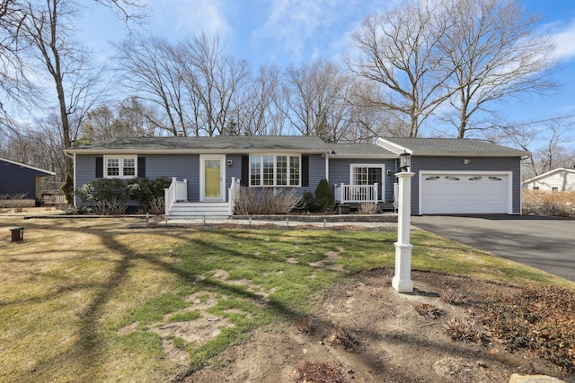 single story home featuring aphalt driveway, a garage, and a front lawn