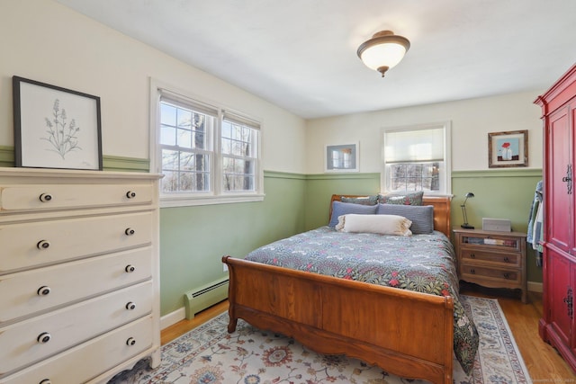 bedroom with light wood-style flooring and a baseboard radiator