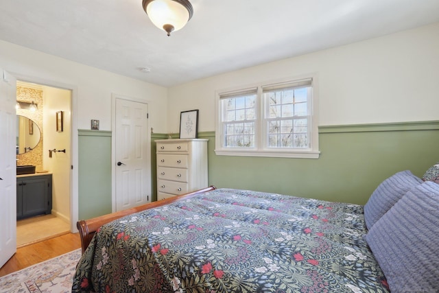 bedroom featuring connected bathroom and wood finished floors