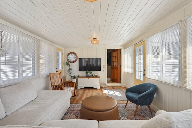 living room featuring a healthy amount of sunlight, wooden ceiling, and wood finished floors