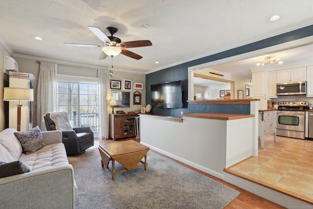 living area featuring ornamental molding, ceiling fan with notable chandelier, recessed lighting, light wood finished floors, and baseboards