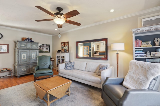 living room with a ceiling fan, crown molding, and wood finished floors