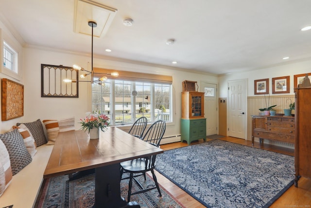 dining area featuring crown molding, baseboard heating, recessed lighting, an inviting chandelier, and wood finished floors