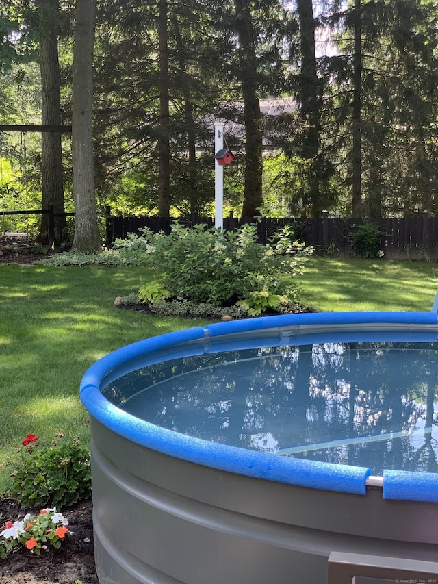 exterior details featuring a swimming pool and fence